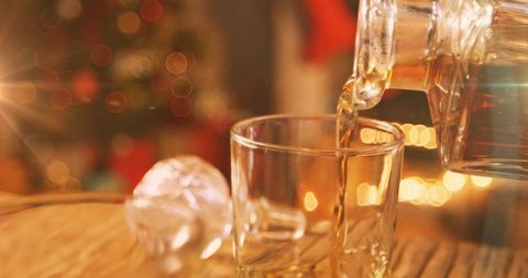 Festive Whiskey Pour with Warm Holiday Lights - Download Free Stock Images Pikwizard.com