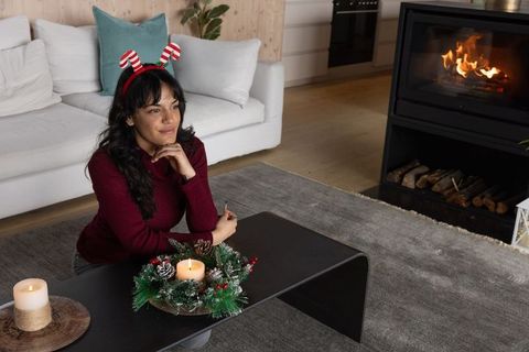 Woman Enjoying Festive Holiday Decor by Cozy Fireplace