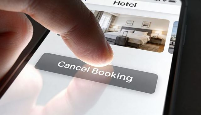 Canceling Hotel Booking on Smartphone Touchscreen Closeup with Hotel Room Preview