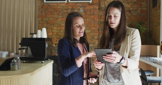 Businesswomen Discussing Digital Strategy with Tablet in Cafe - Download Free Stock Images Pikwizard.com