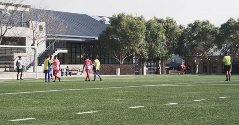 Young Soccer Players Practicing on Sunny Football Field