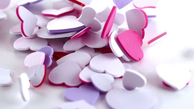 Heart-shaped pink and purple confetti falling in slow motion. Perfect for use in wedding invitations, Valentine's Day promotions, or any romantic-themed projects. Great for decorations, party planning resources, and festive events.