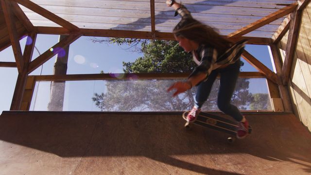 Caucasian female confidently skateboarding on a halfpipe outdoors, emphasizing dynamic movement and skill. Bright sunlight lends vibrancy making it perfect for promotional materials related to active lifestyles, skateboarding events, or fitness campaigns. Suitable for use in ads highlighting youth culture and extreme sports enthusiasts.