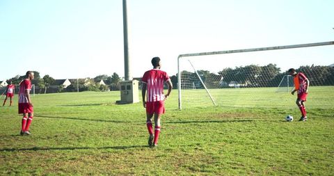 Soccer players on field during team practice near goal