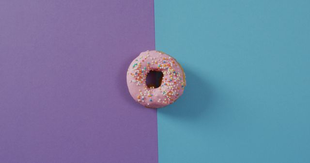 Colorful background emphasizing pink frosted donut with sprinkles. Great for food blogs, dessert branding, minimalistic designs, and creative ads.