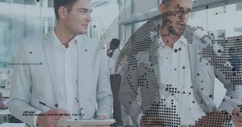 Business team collaborating over tablet and clipboard through dotted glass in modern office