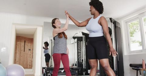 Diverse Fitness Training Duo Celebrates Success with High Five