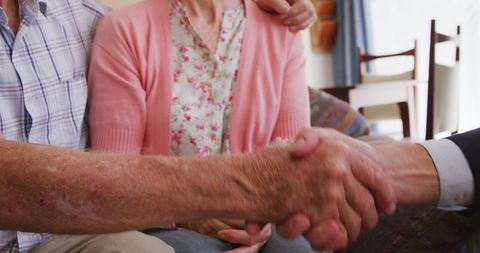Senior couple shaking hands with smartly dressed man