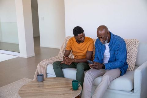 Father and Son Relaxing in Living Room with Smartphone