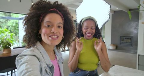 Diverse women recording lifestyle content at kitchen island with softbox lighting
