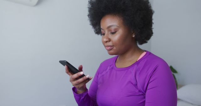 Smiling Woman Using Smartphone in Purple Sportswear - Download Free Stock Images Pikwizard.com