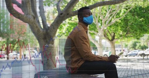 Man in Urban Park Analyzing Financial Data on Smartphone