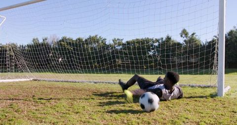 Teen Goalkeeper Successfully Saves Goal on Soccer Field