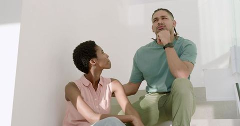 Contemplative Couple Sitting on Modern Home Stairs