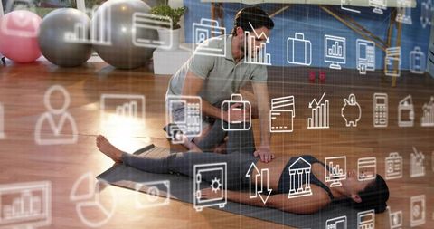 Trainer assisting woman with guided floor stretch on gym mat with finance tech overlay
