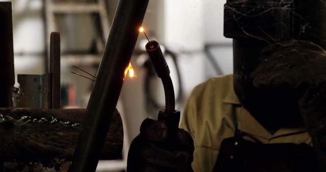 Welder working in an industrial workshop, with sparks flying from the welding torch. Can be used for illustrating manual labor, industrial work environments, safety in welding, and skilled trades.