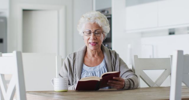 African american senior woman reading a book while sitting at home. retirement senior lifestyle living in quarantine lockdown concept