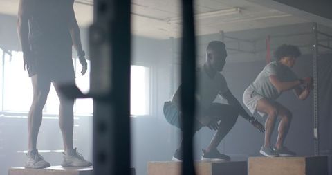 Group Workout with Box Jumps in Industrial Gym Setting
