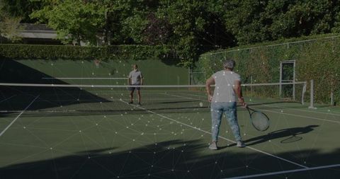 Energetic Seniors Engaging in Friendly Tennis Match Outdoor