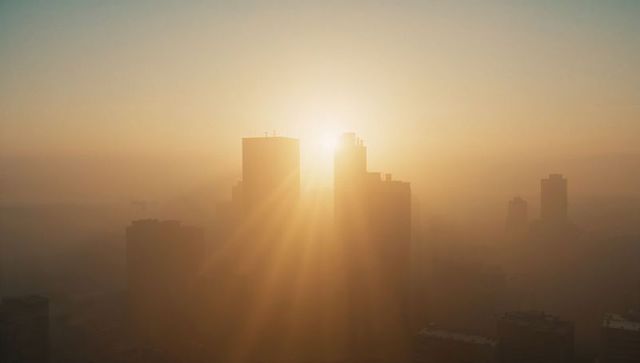 Sunrise over cityscape with skyscraper silhouettes in golden light