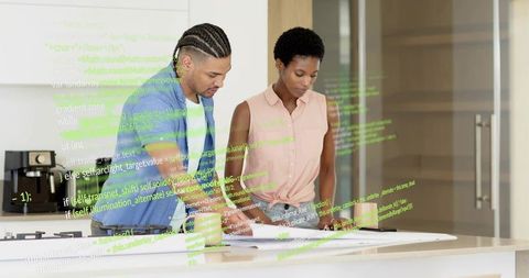 Developers reviewing code printouts in modern office kitchen collaborating on project