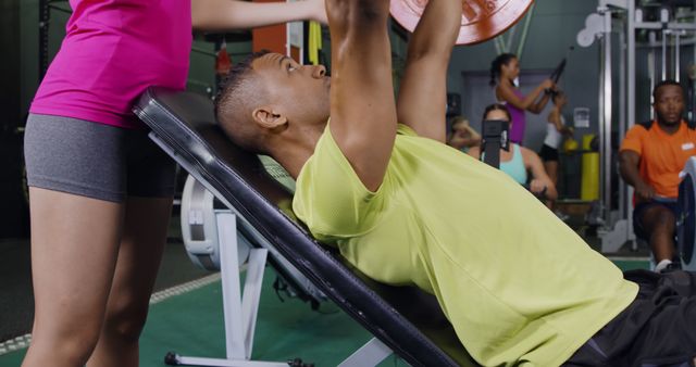 Man in gym lifting weights with spotter for support - Download Free Stock Images Pikwizard.com