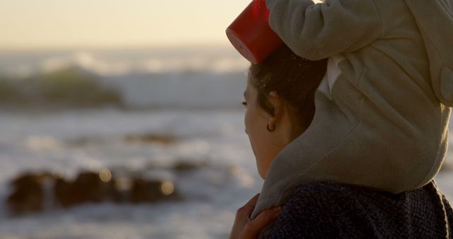 Mother Carrying Child on Shoulders During Sunset at Beach - Download Free Stock Images Pikwizard.com