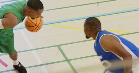 Player dribbling past defender in intense one-on-one basketball play