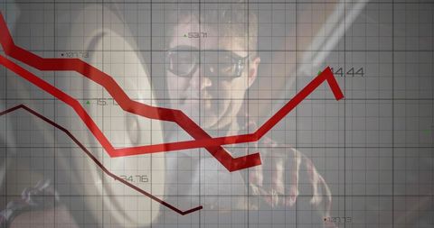Professional analyst examining red line graphs for financial insights