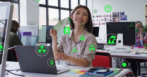 Creative designer in modern office with green concept icons