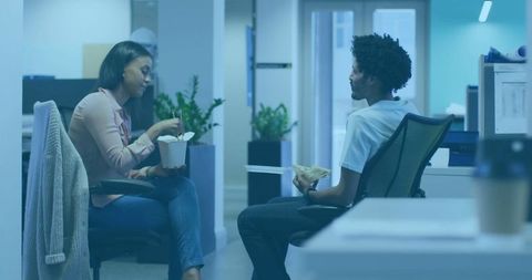 Colleagues enjoying lunch together in casual office setting