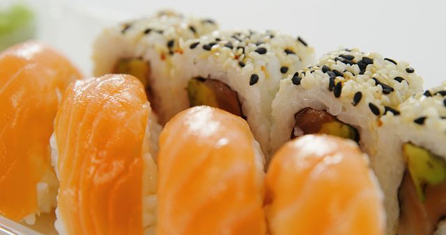 A close-up view of delicious sushi rolls and nigiri, showcasing the fresh ingredients and sesame seed garnish, with copy space. Sushi is a popular Japanese cuisine known for its variety of flavors and artistic presentation.