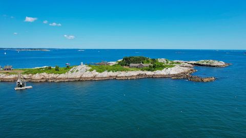 Rocky Coastal Island Revealing Lush Green Shrubbery, Rustic Buildings and Pier over Turquoise Sea