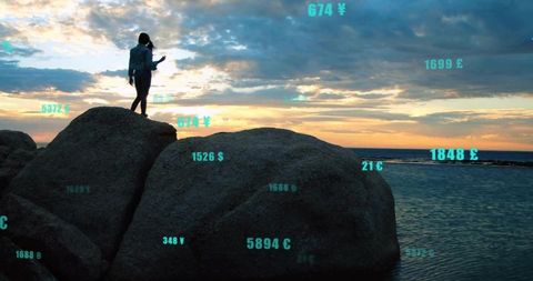 Silhouette of Woman on Boulders Displays AR Currency at Sunset