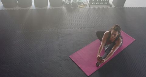 Fit Woman Stretching on Yoga Mat in Modern Gym Setting