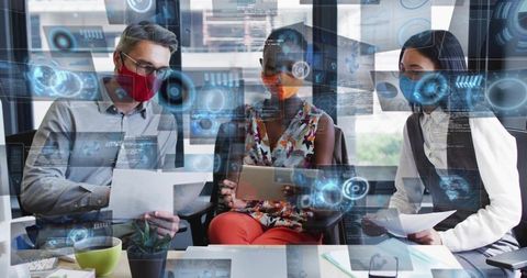 Office team collaborating with tablet and documents wearing masks, futuristic hud overlays