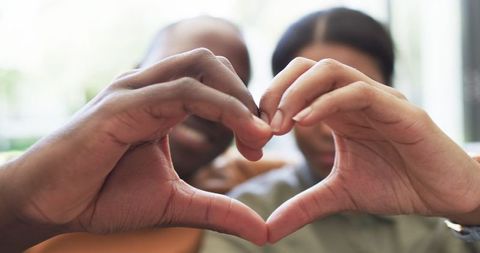 Couple Forming Heart Shape with Hands Showing Affection