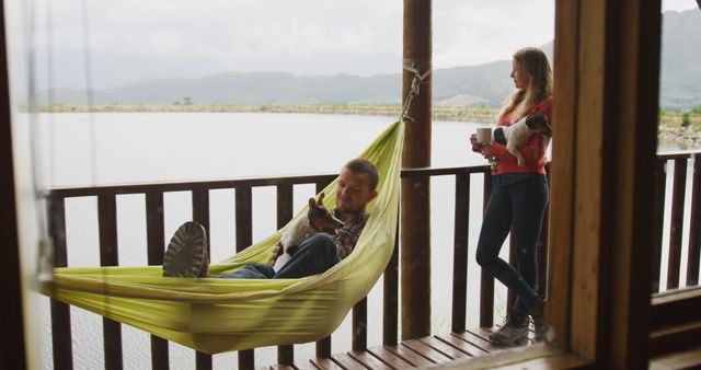 Couple Relaxing on Lakefront Porch with Dogs - Download Free Stock Images Pikwizard.com