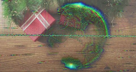 Presenting glitching festive gift on wooden table with pine sprigs and tv static distortion