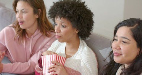 Diverse Friends Watching Movie Night Together on Couch Sharing Popcorn and Laughing