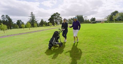 Senior Women Enjoying Golf Stroll on Bright Fairway