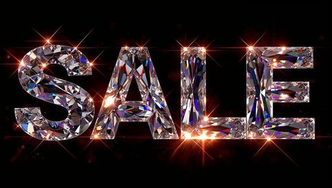 Glittering crystal sale letters reflecting prismatic light with starburst flares