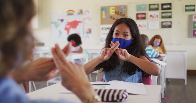 Girl Learning Sign Language in Classroom with Masked Teacher - Download Free Stock Images Pikwizard.com