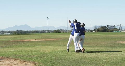 Youth Baseball Team Celebrating Victory Hug in Afternoon Game