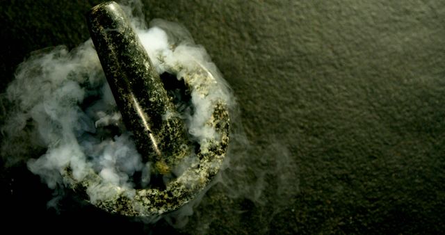 A metal object is engulfed in smoke, creating a dramatic and mysterious atmosphere. The smoke adds a dynamic quality to the image, suggesting a recent action or reaction involving the object.