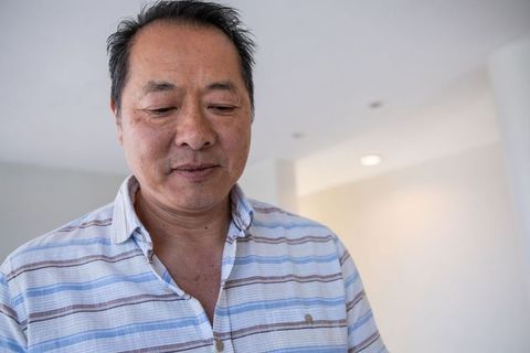 Mature asian man in minimalist home interior