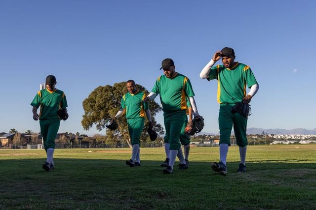 Baseball team walking off field after inning in green yellow uniforms showing camaraderie