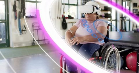 Woman in wheelchair performing VR rehab exercises in vibrant therapy gym