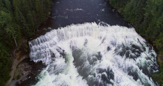Aerial view captures the majestic beauty of a cascading waterfall surrounded by dense forest - Download Free Stock Photos Pikwizard.com