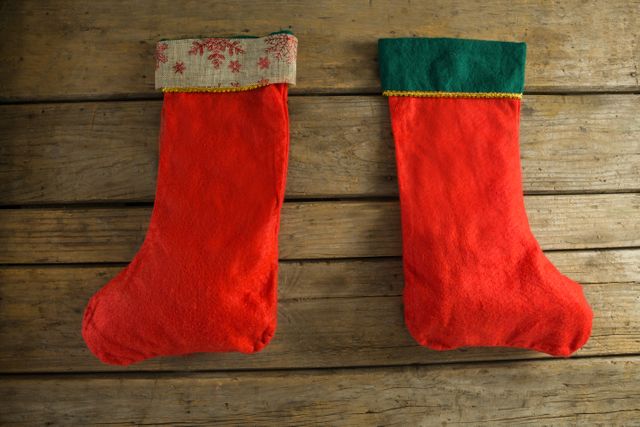 Two Christmas stockings hanging on rustic wooden wall - Download Free Stock Photos Pikwizard.com